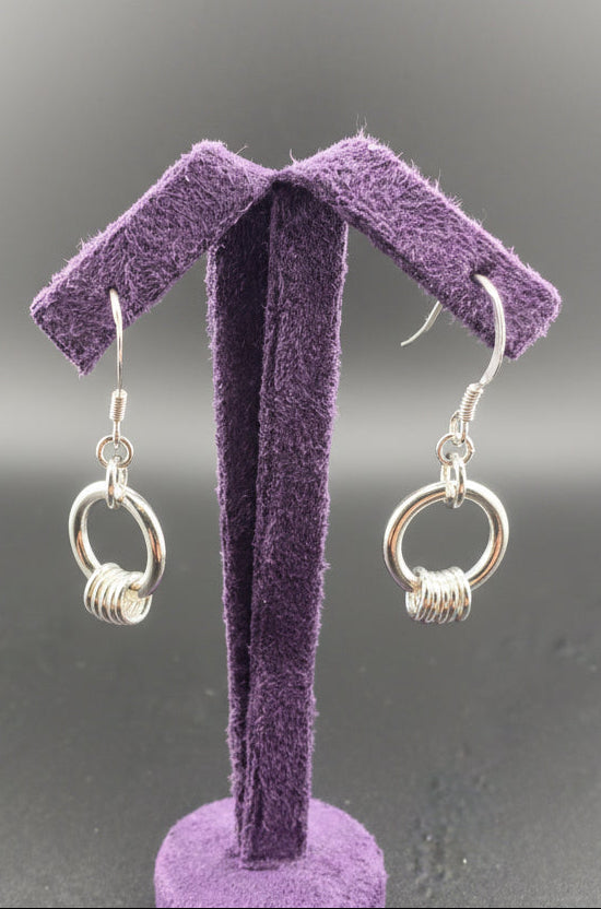 Silver drop earrings with a hoop and 5 fidget rings around them