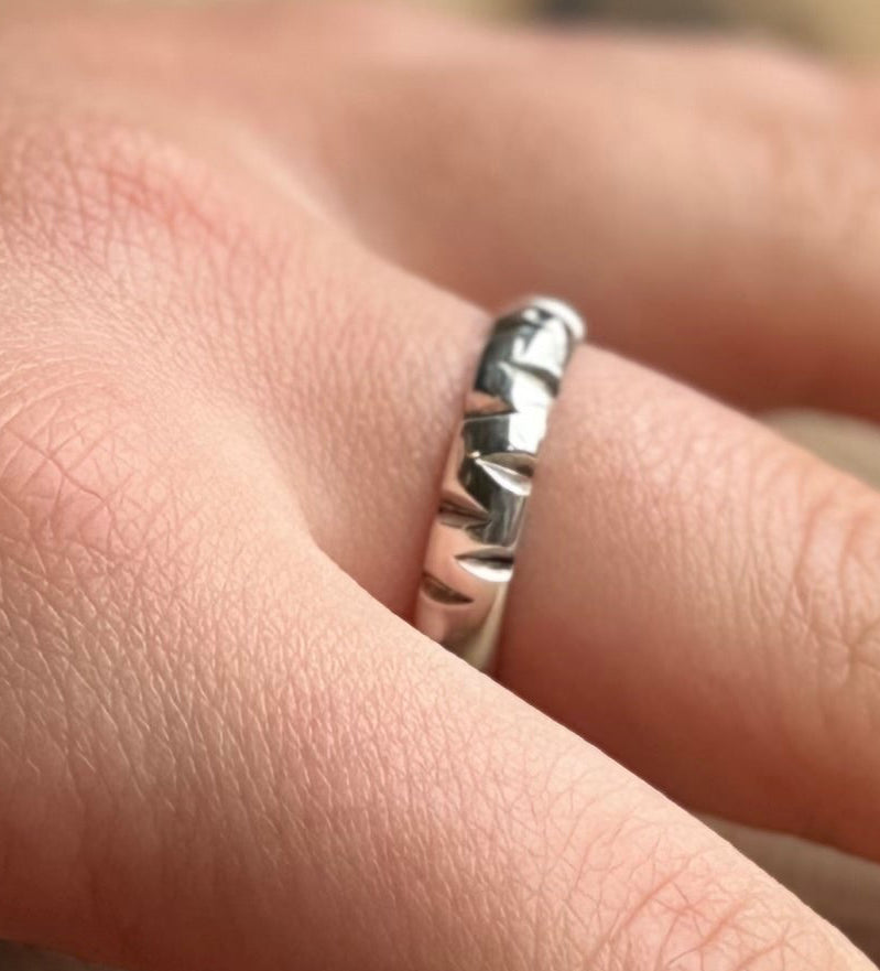 Silver ring band with triengle cut outs on hand
