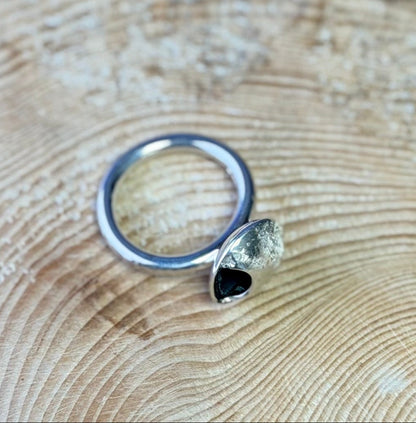 Silver ring with a moon on a wooden surface with a blue background