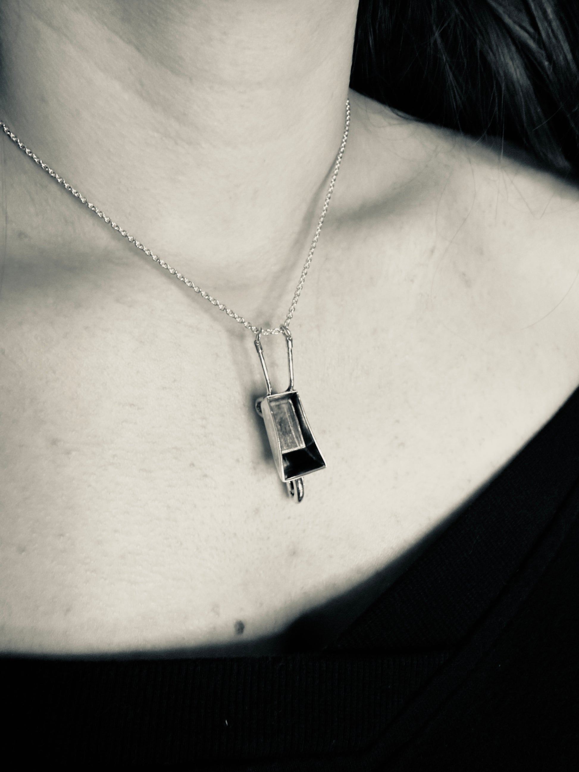 Necklace with a pendant worn by a person, black and white photo