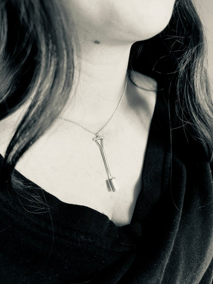 Person wearing a necklace with a unique pendant
