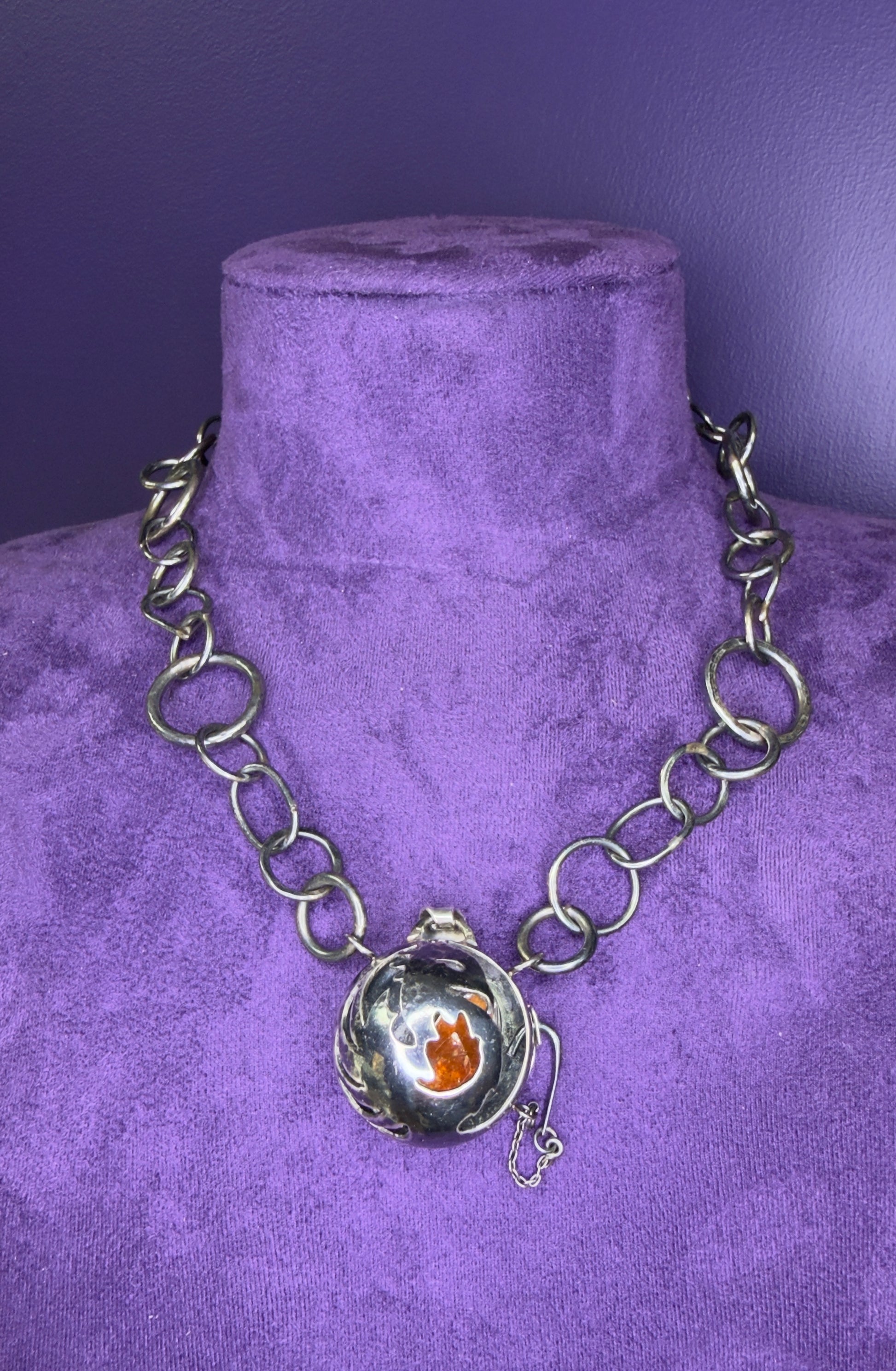 Silver chain necklace with a pendant on a purple velvet mannequin