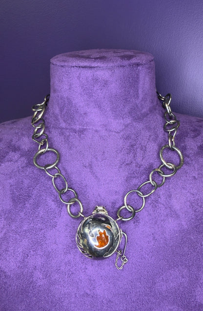 Silver chain necklace with a pendant on a purple velvet mannequin