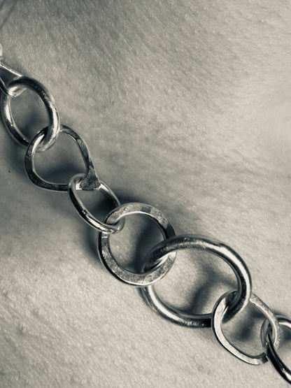 Close-up of a silver chain on a textured gray background