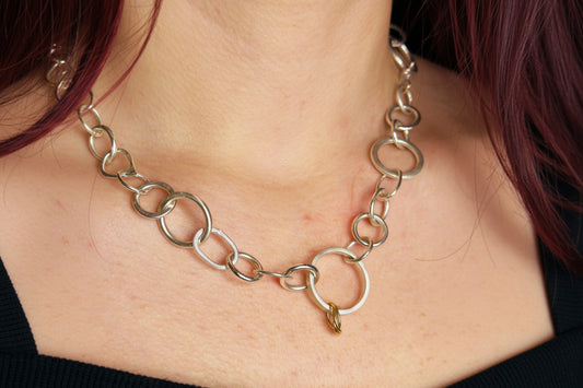 Silver and 9ct yellow gold chain necklace worn by a person