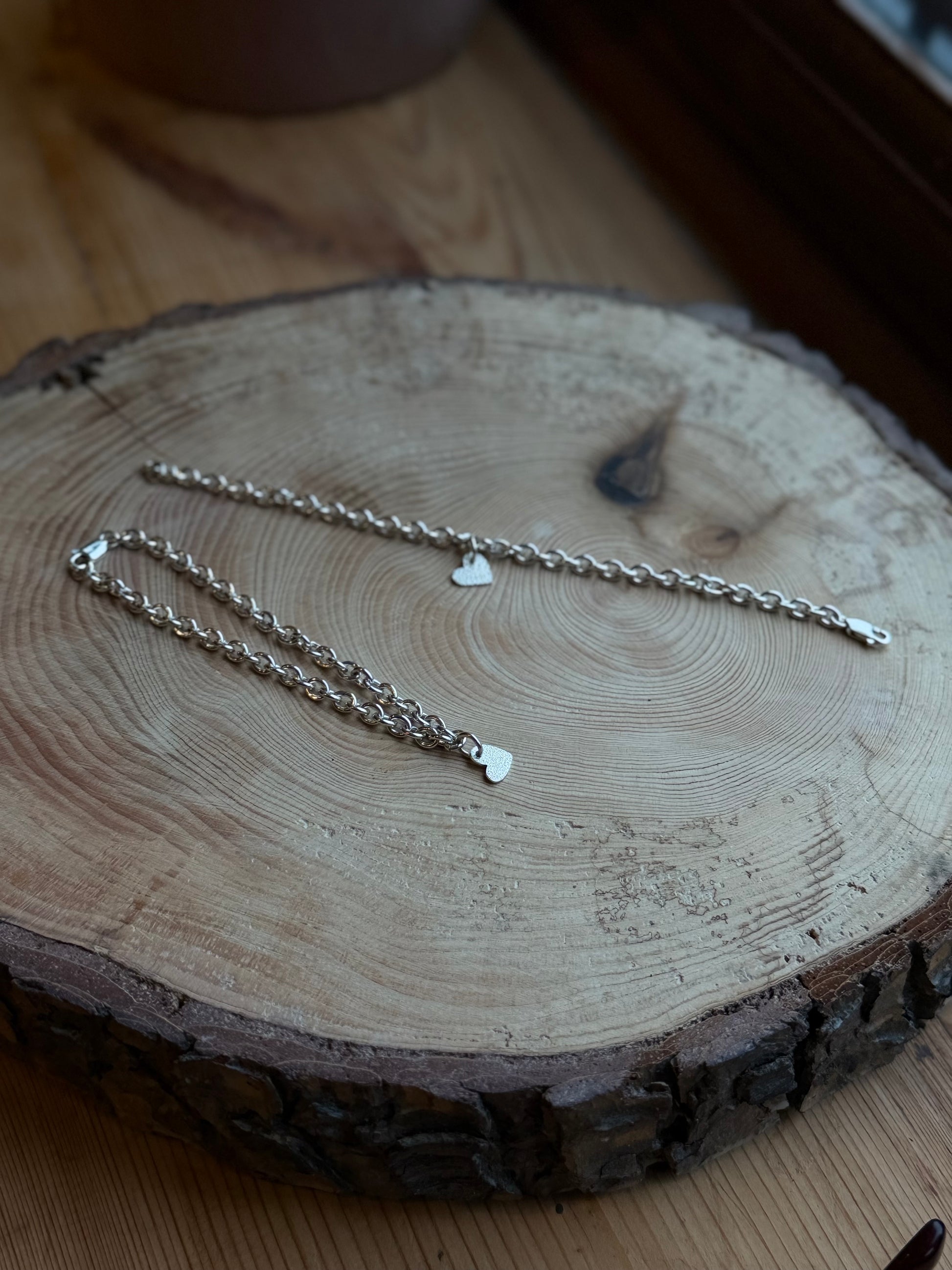 Two bracelets to show what charm would look like on bracelet, sat on wood