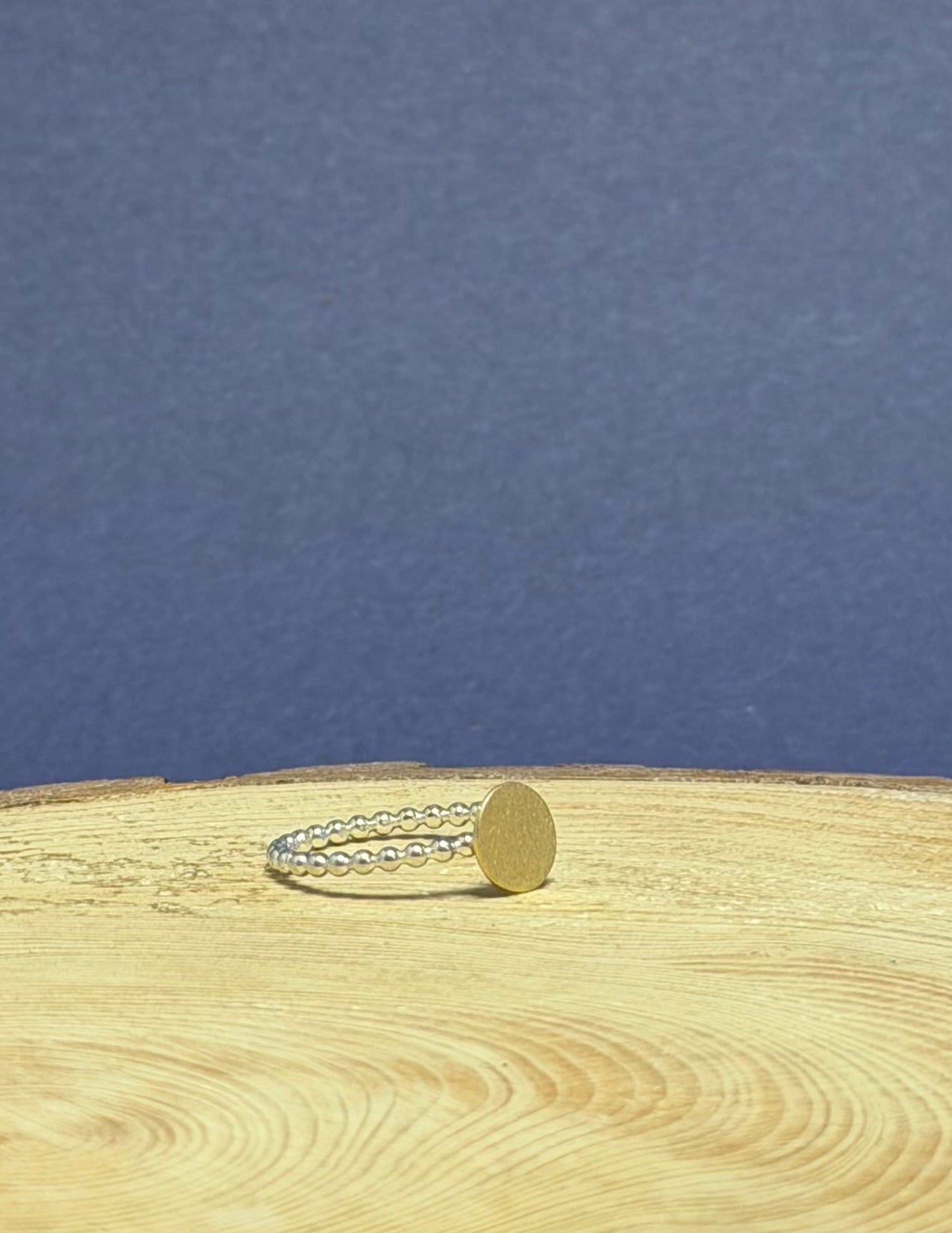 Close-up of a ring on a  tree stump with visible annual rings against a blue background
