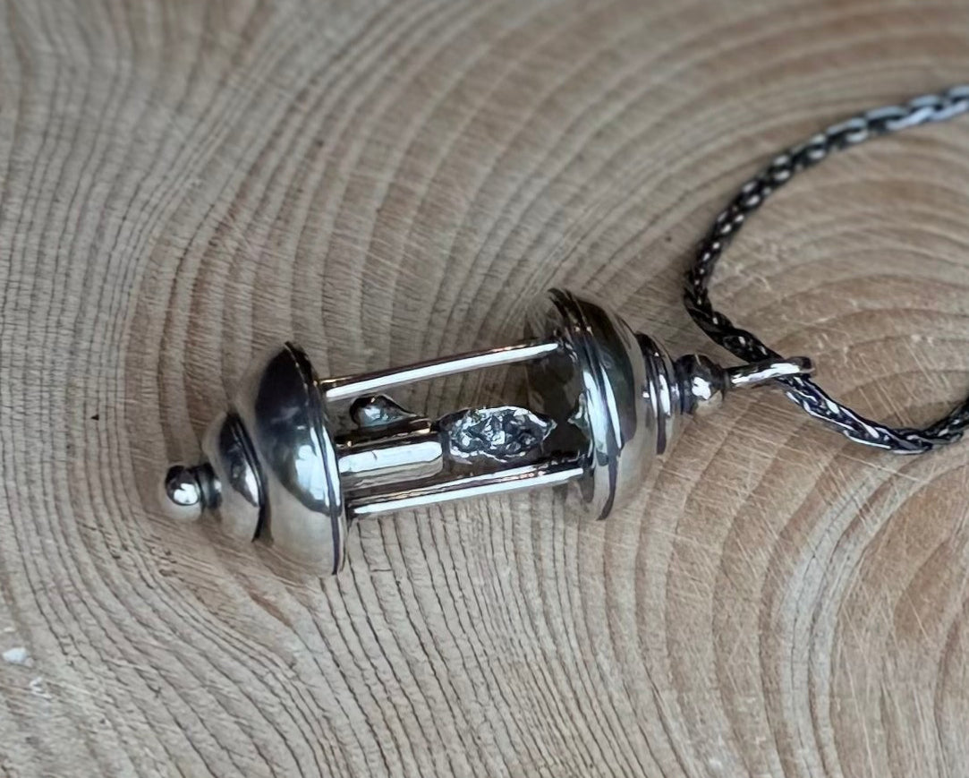 Silver lantern pendant on wood