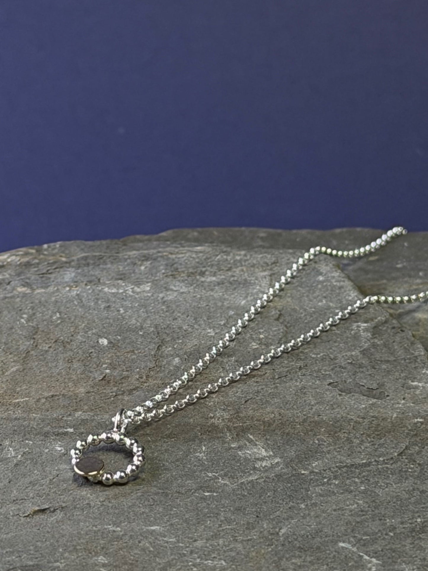 Beaded circle pendant with small textured 9ct yellow gold disc