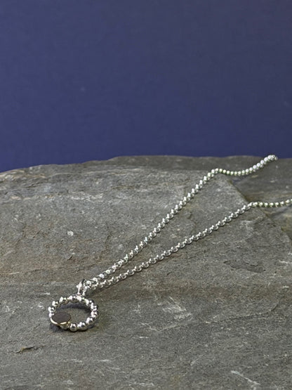 Beaded circle pendant with small textured 9ct yellow gold disc