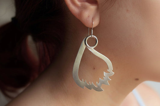 Phoenix feather negative drop earrings on model