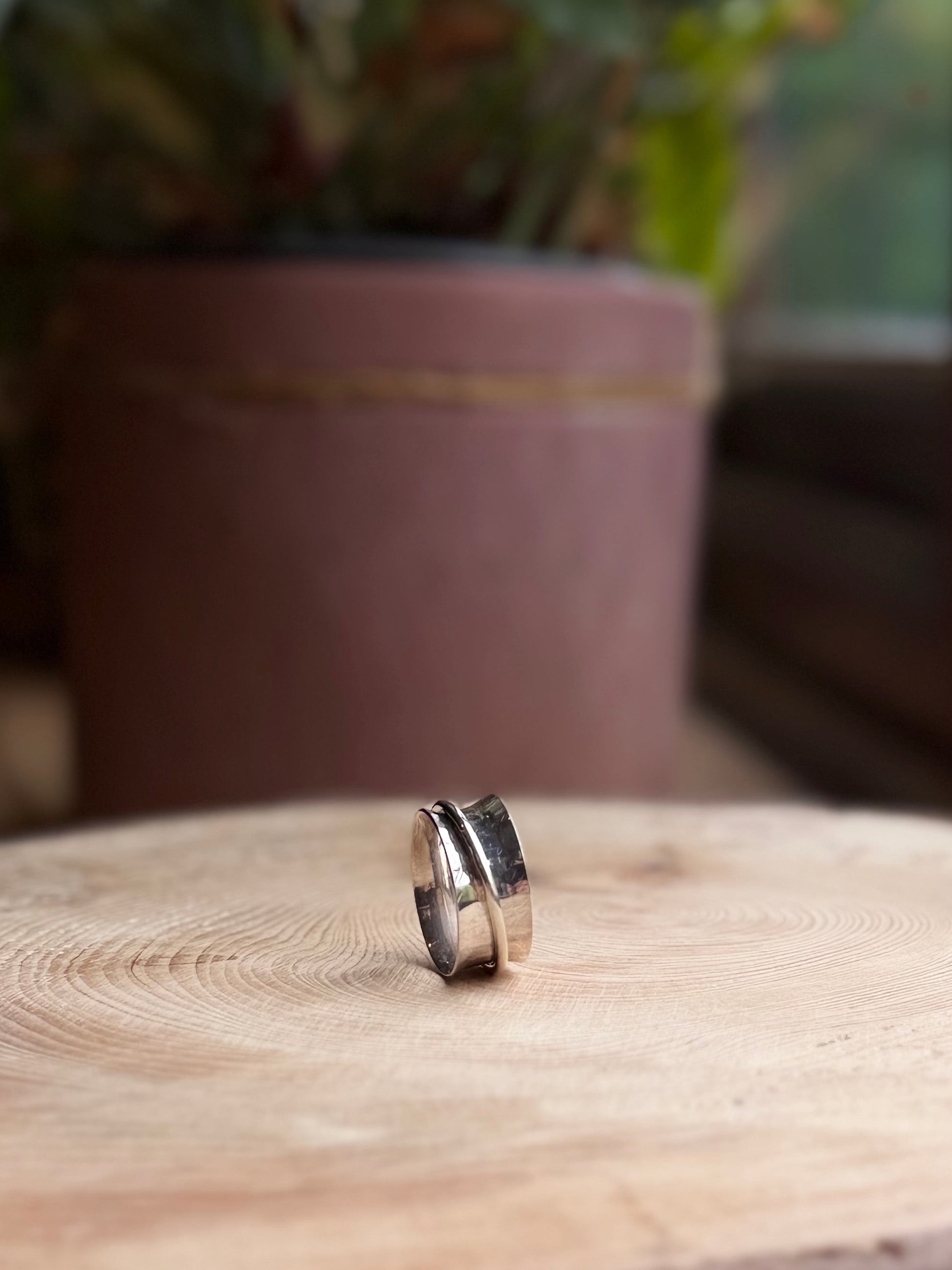 Hammered spinner ring on wooden base