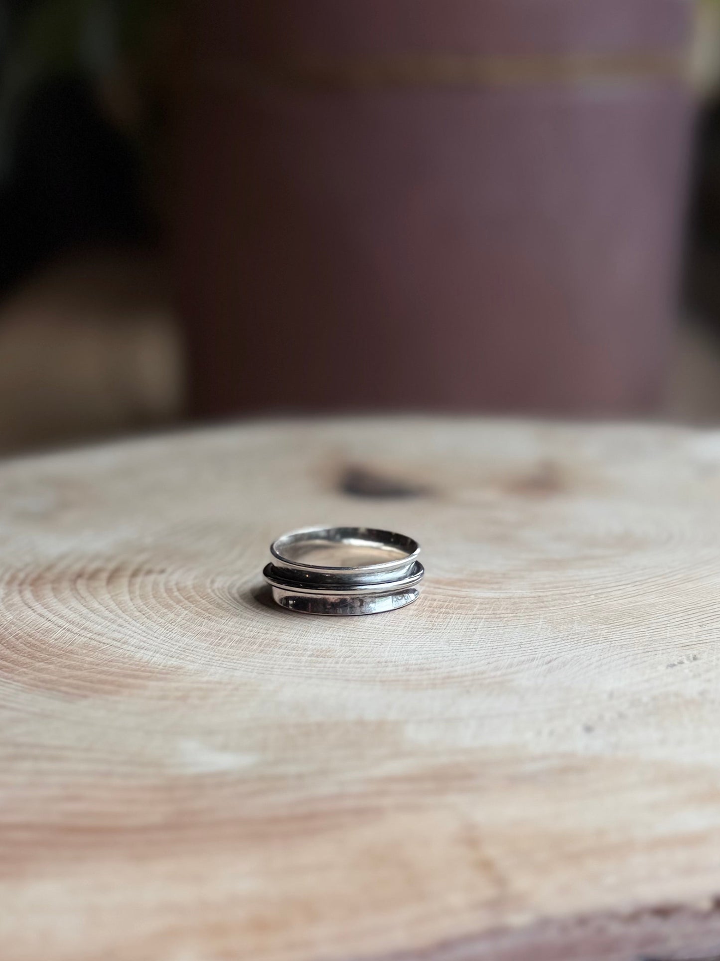 Oxidised silver spinner ring on wood