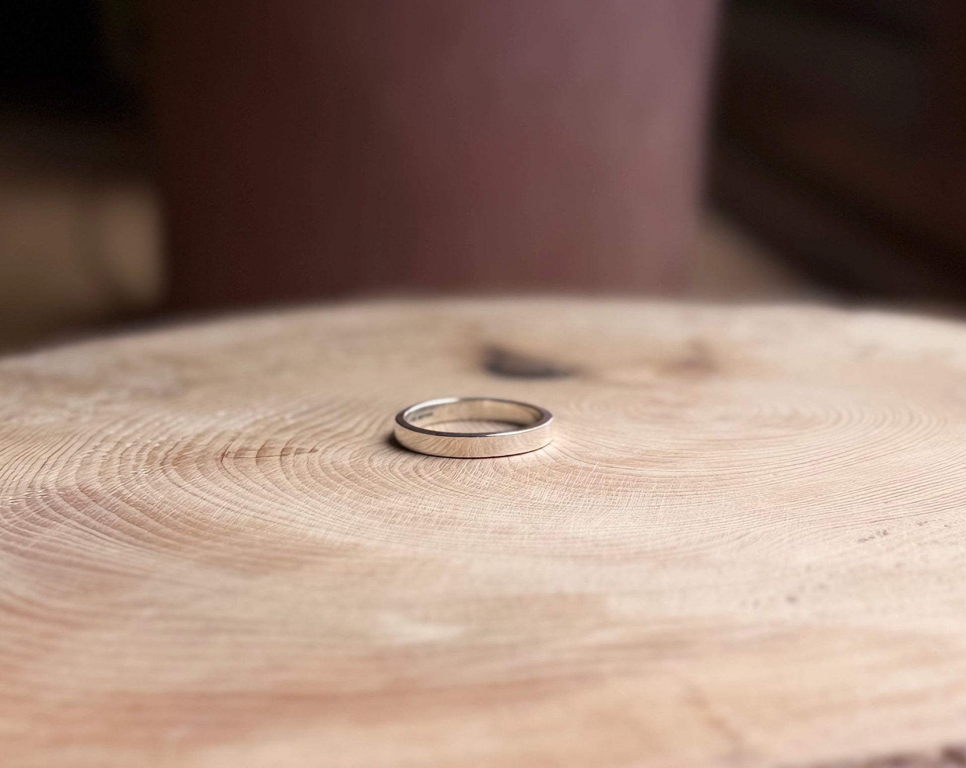 Flat profile ring made of silver on wood