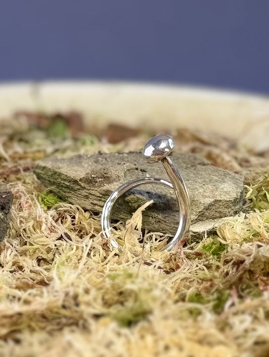 Silver  mushroom ring on a stone surface with moss