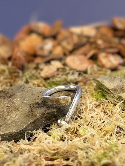 Small mushroom ring on a bed of moss and small stones against a dark blue background