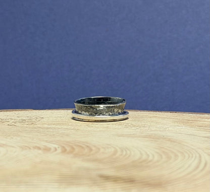 Silver ring on a wooden surface with a blue background