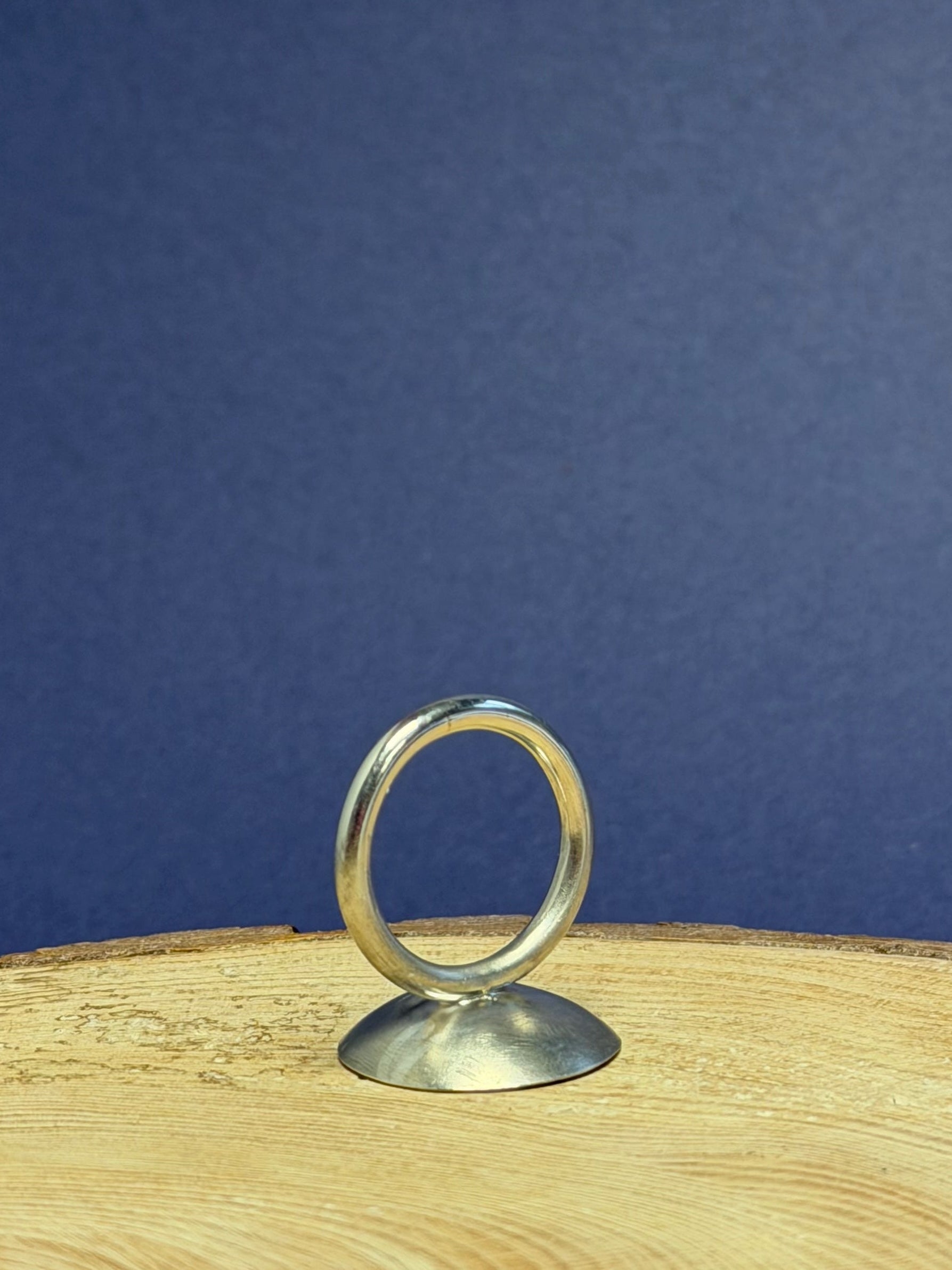 Domed ring on a wooden surface with a blue background