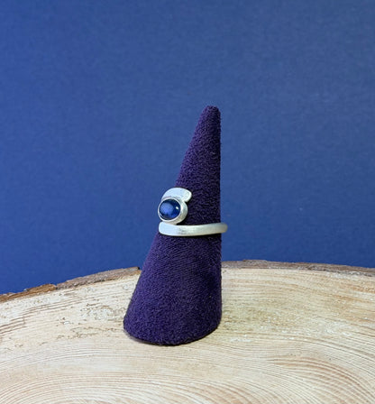 Ring on a purple felt cone against a blue background