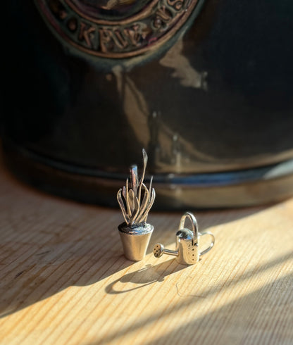 Close up of dracaena trifasciata pendant next to watering can pendant