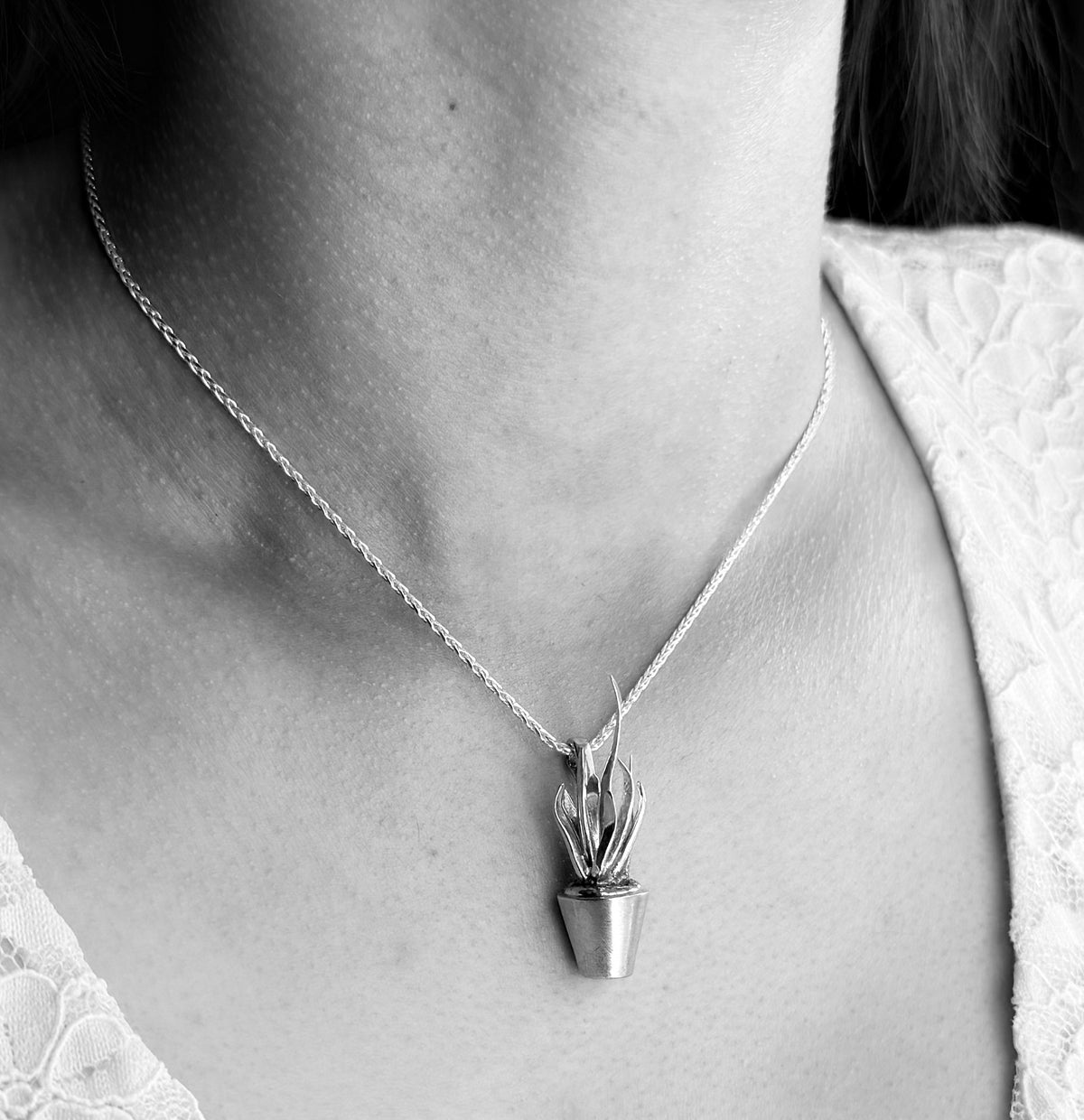 dracaena-trifasciata-pendant worn around neck, black and white image