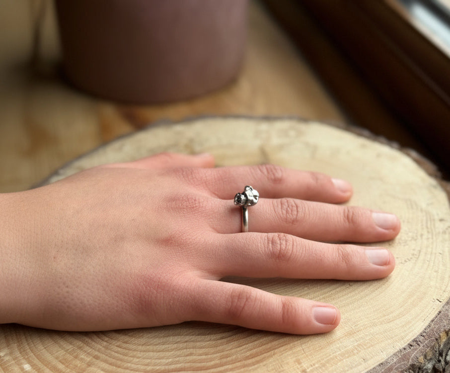 Alchemy ring satin finish on hand, resting on wood