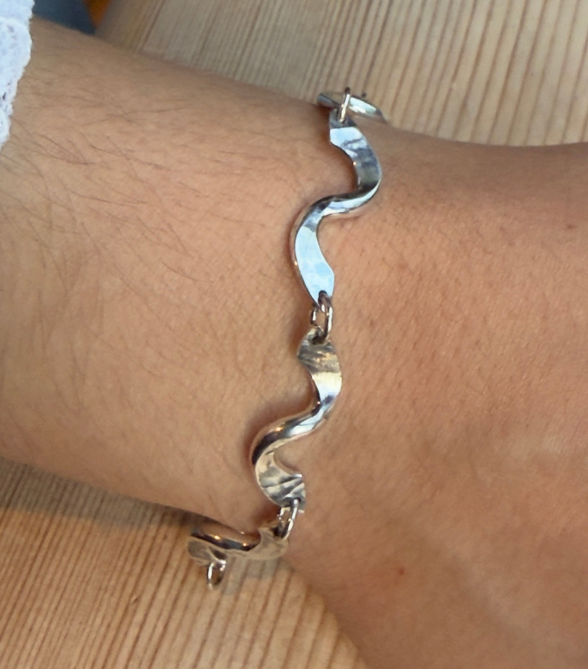Close-up of the bracelet’s curved twist links, showing the hammered texture and small connecting rings.