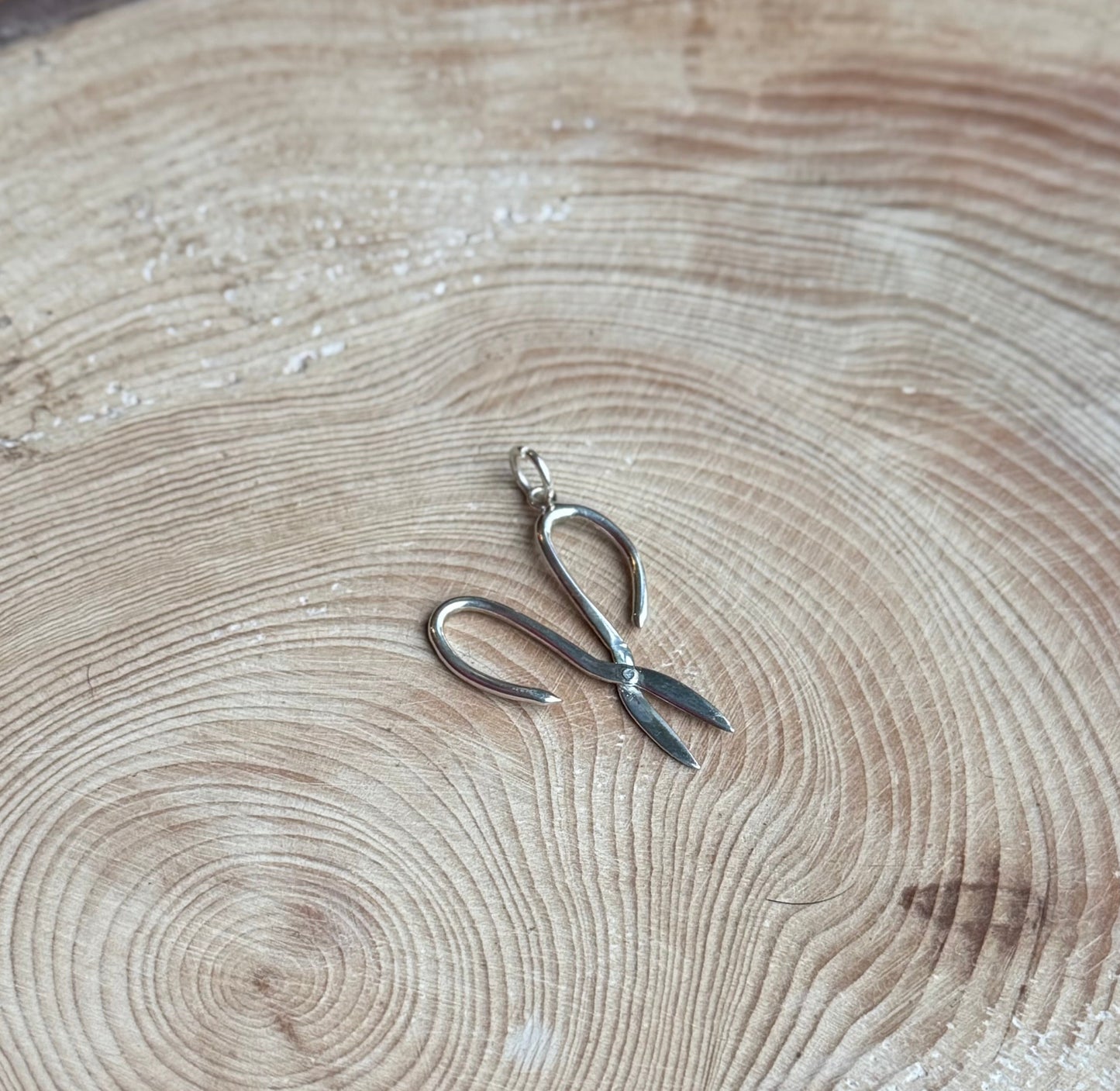 Silver Garden scissors charm on wood