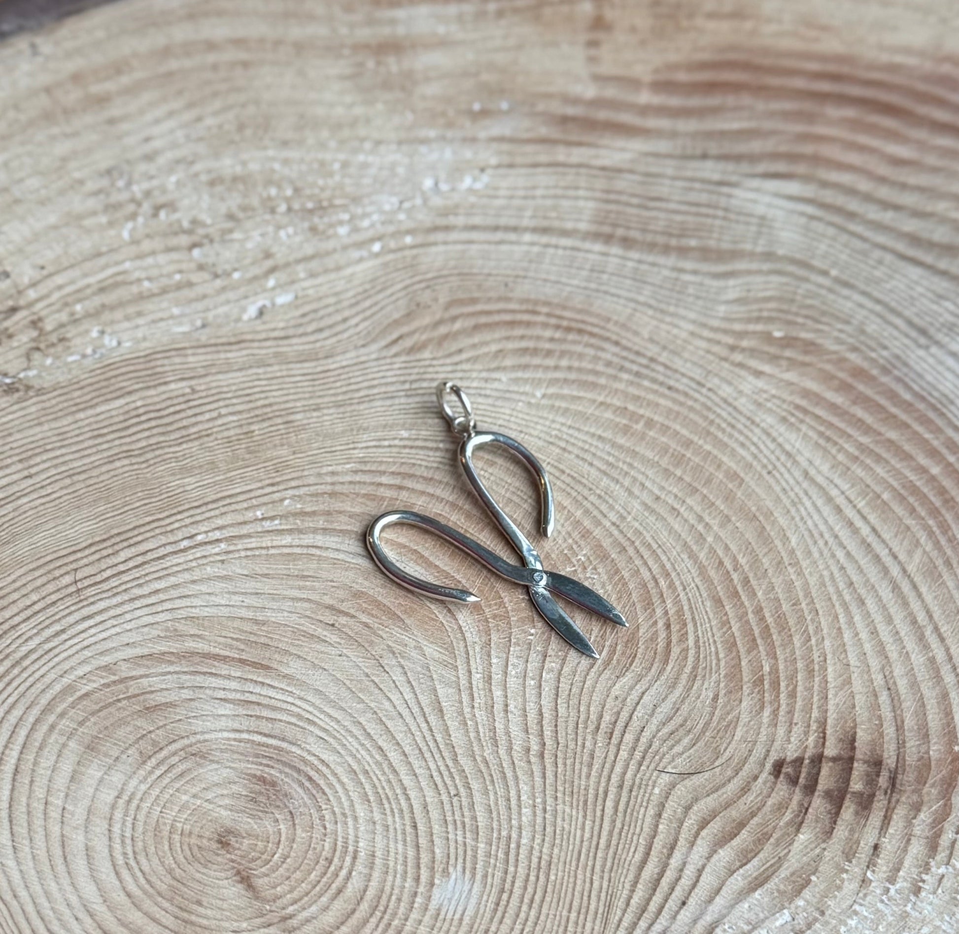 Silver Garden scissors charm on wood