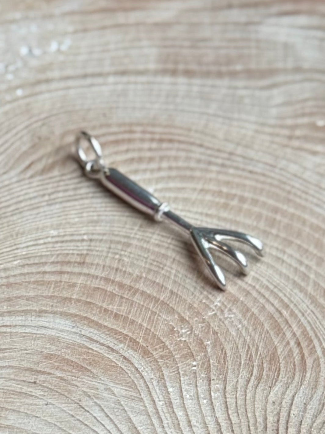 Hand cultivator charm on wooden table