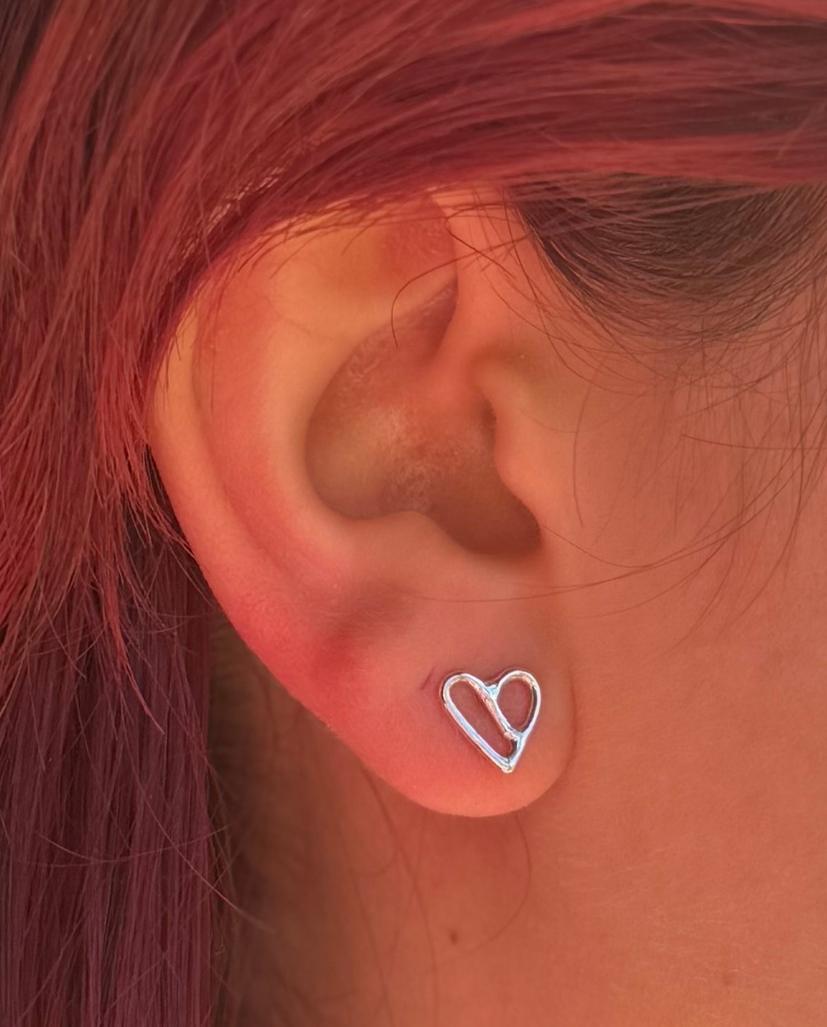 Silver stud on ear. Colour image