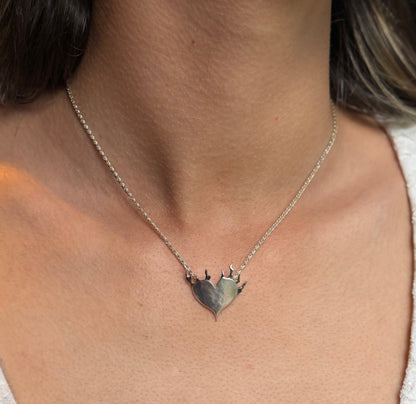 Front view of the Love Set on Fire silver pendant worn on a necklace, with a satin heart and polished, oxidised flames.