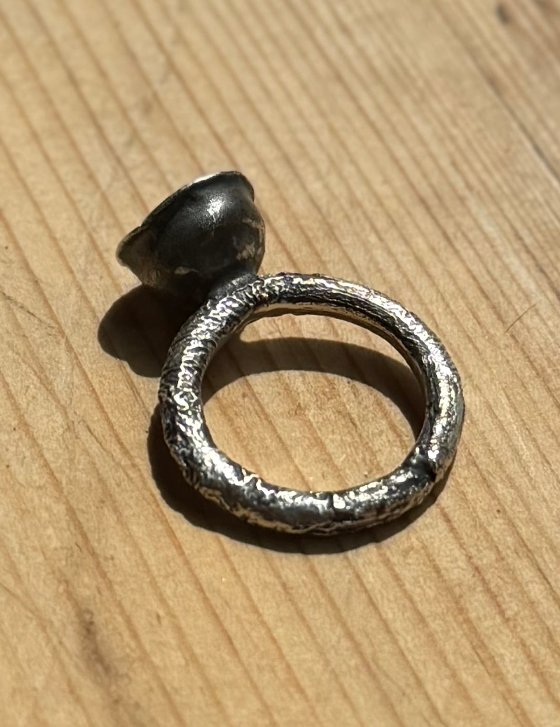 molten silver up ring on wood