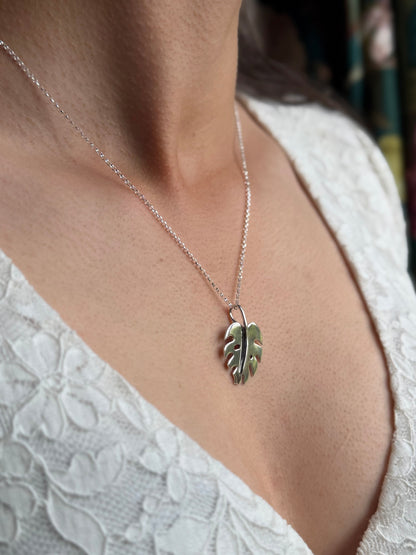 Monstera pendant in silver, on model in white lace top