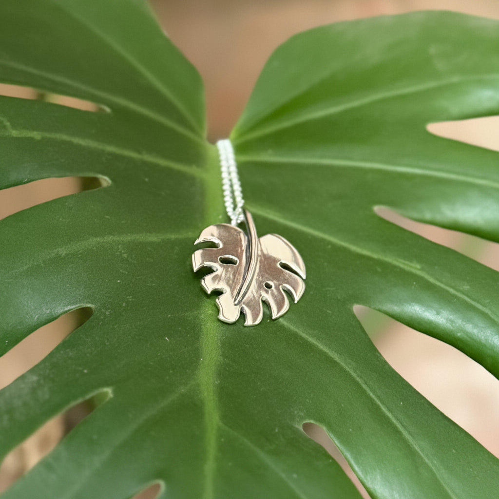 Monstera leaf pendant made in silver, sat on a leaf
