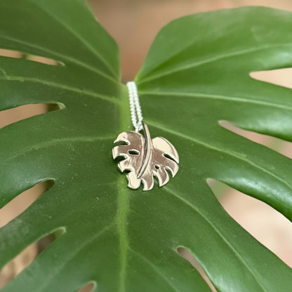 Monstera leaf pendant made in silver, sat on a leaf