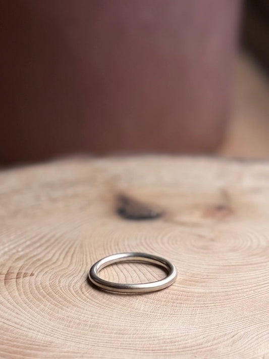 Silver round profile ring band, satin finish on wood