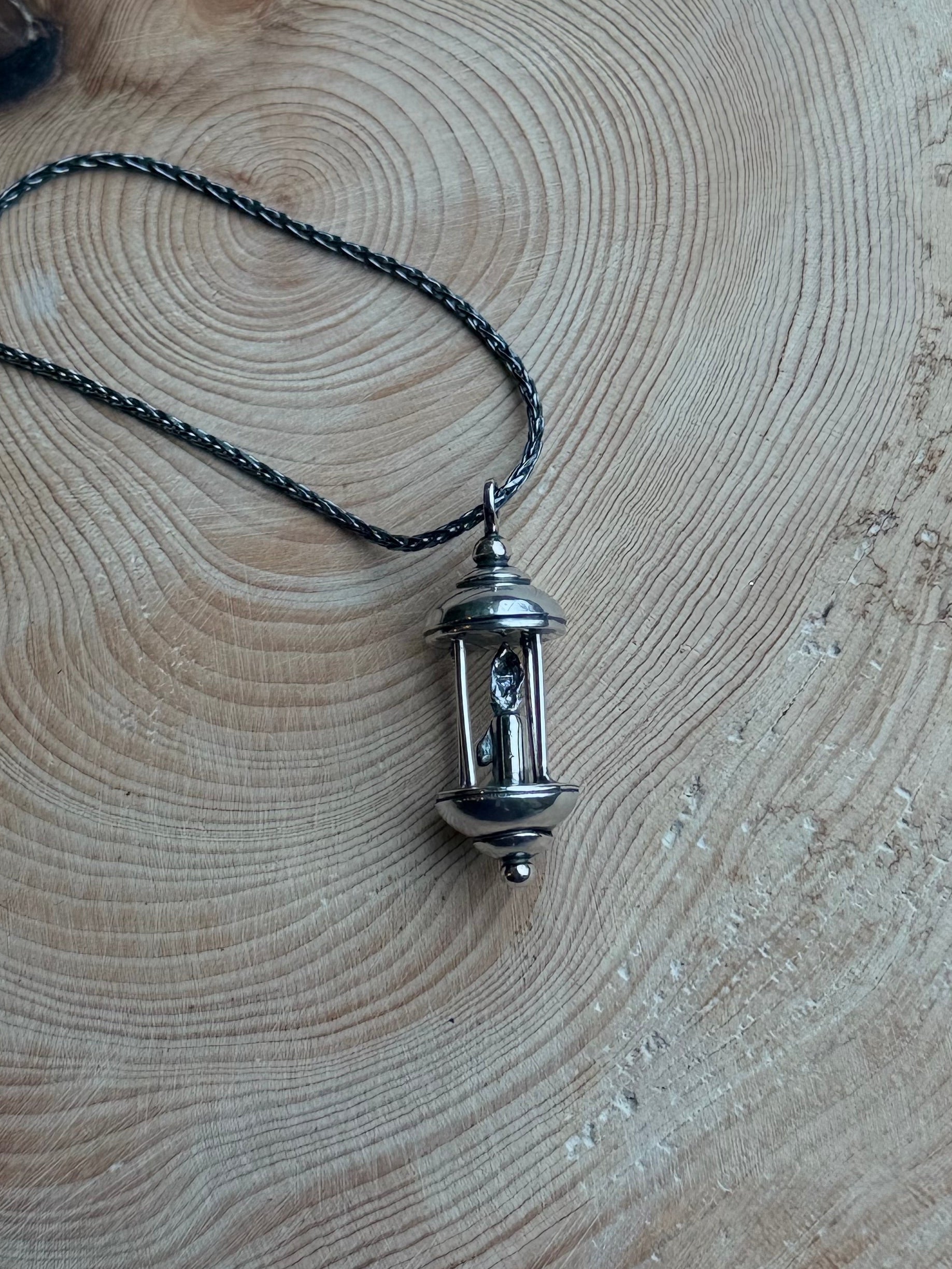 Silver lantern pendant on wood