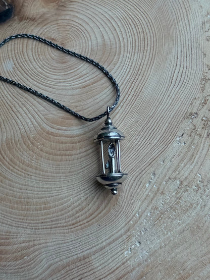 Silver lantern pendant on wood
