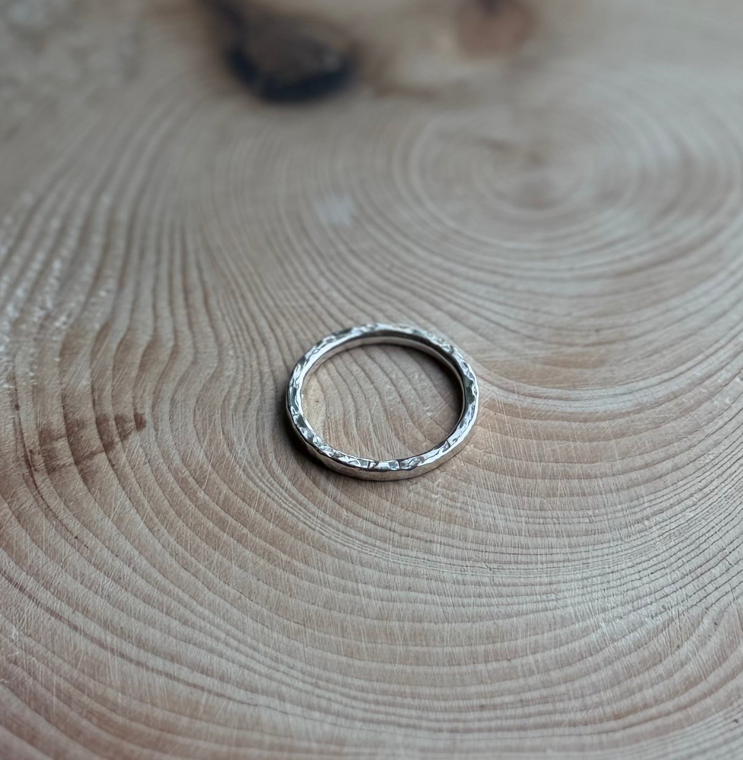 Silver hammered ring on wood