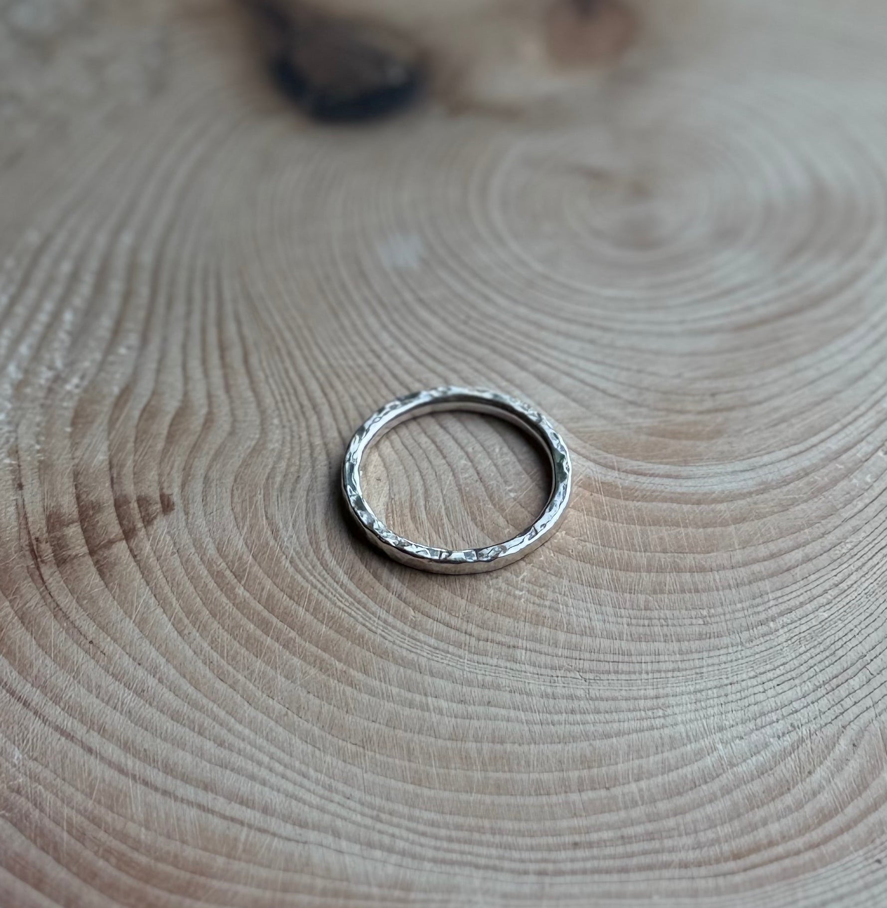 Silver hammered ring on wood