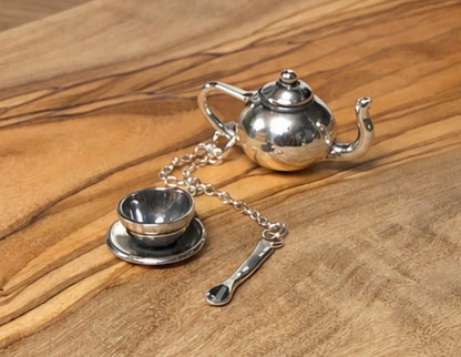 Teapot, teacup and soon made in silver on a wooden plinth 