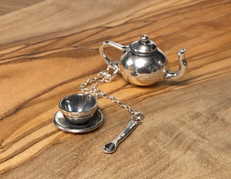 Teapot, teacup and soon made in silver on a wooden plinth 
