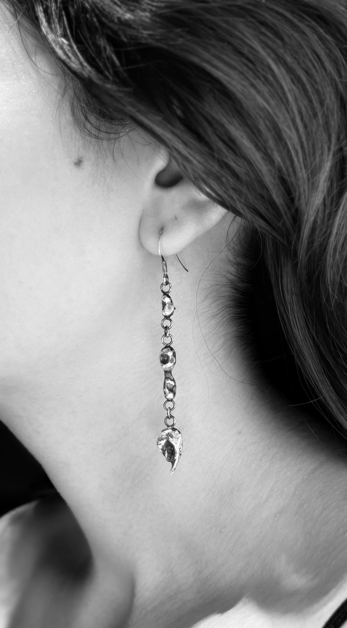 Black-and-white close-up of an Alchemy drop earring, showing three irregular silver nuggets joined by small rings.