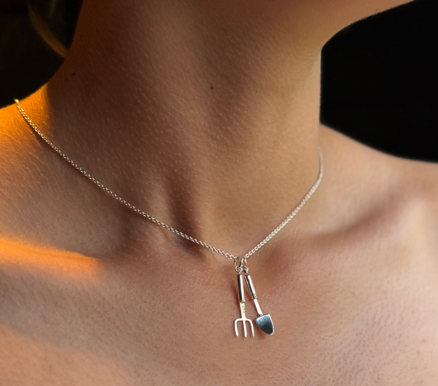 Silver miniature trowel and hand fork on belcher chain worn by model